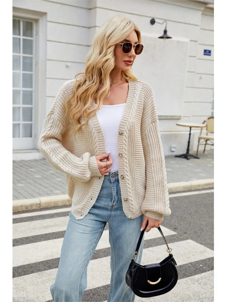 Beige kofta bärd öppen över vit topp med jeans och svart handväska